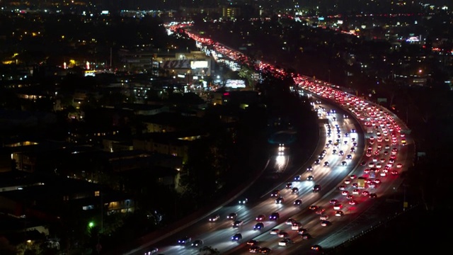 空中向后拍摄的汽车在夜间照明城市道路上移动-卡尔弗城，加利福尼亚视频素材