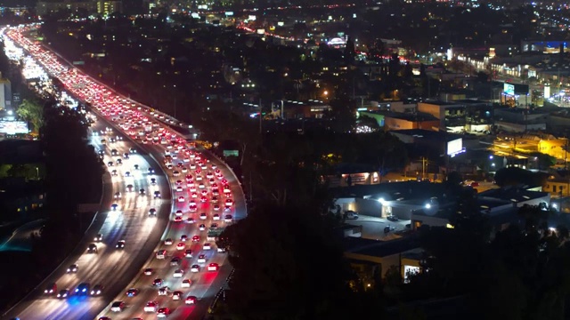 空中向前拍摄的照明汽车在夜间住宅城市道路上移动-卡尔弗城，加利福尼亚视频素材