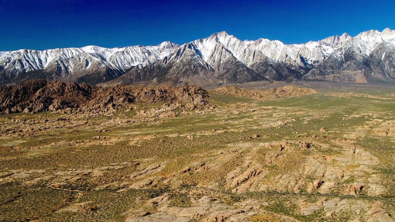 空中风景的雪山，无人机下降向后半干旱景观在阳光灿烂的一天-大松树，加利福尼亚视频素材