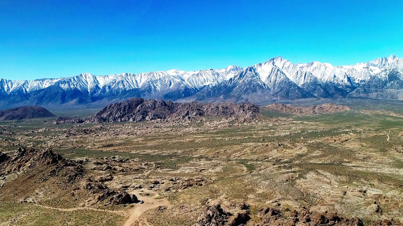 空中风景的雪山山脉反对晴朗的天空，无人机飞行在宁静的沙漠景观-大松树，加利福尼亚视频素材