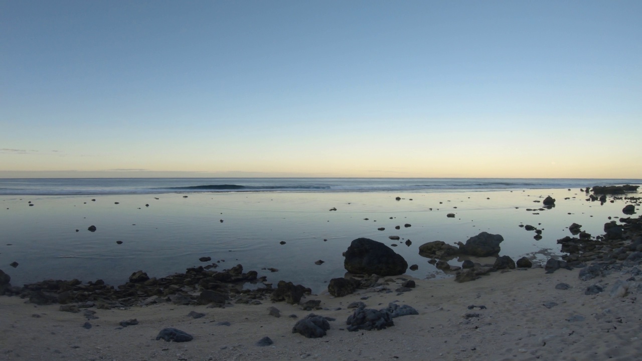 海洋海岸线海湾沙质岩石海滩与椰子树的水平窗格视图，在日落黎明时分，在泻湖和平蛤水波内，眺望东太平洋的地平线视频素材