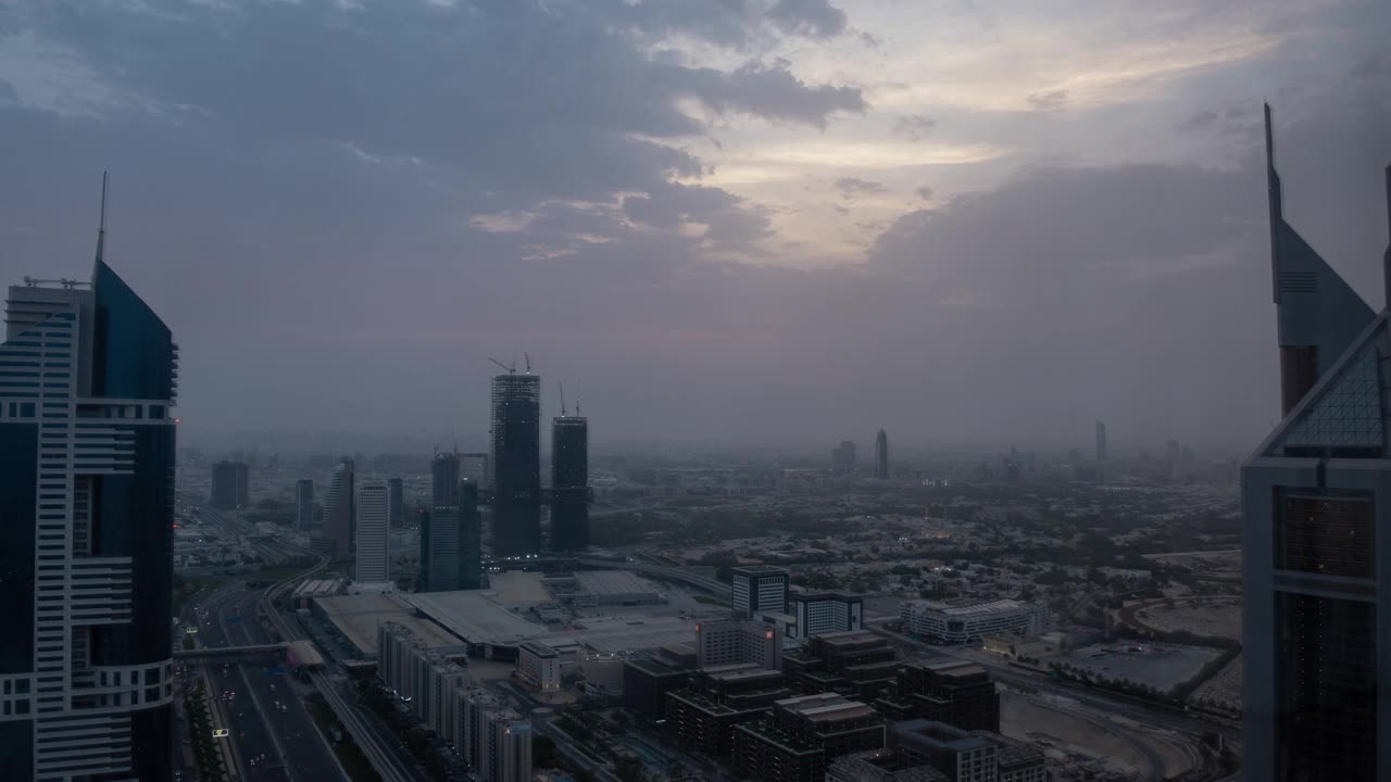 现代摩天大楼和繁忙的夜间高速公路昼夜过渡时间在豪华的迪拜市中心。塔顶鸟瞰图。路口交通。鱼眼镜头。迪拜、美国。视频素材