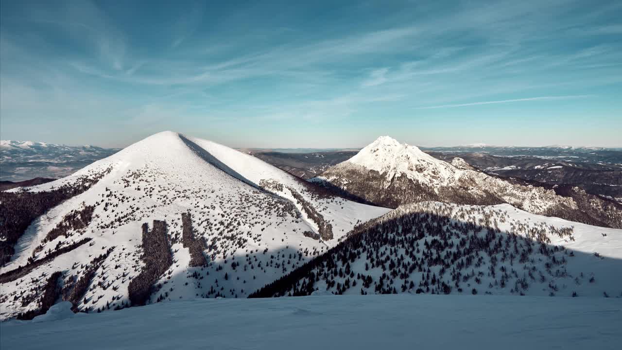 冬季山地景观晴天有云，天空蔚蓝。雪山皑皑，风光尽收眼底视频素材