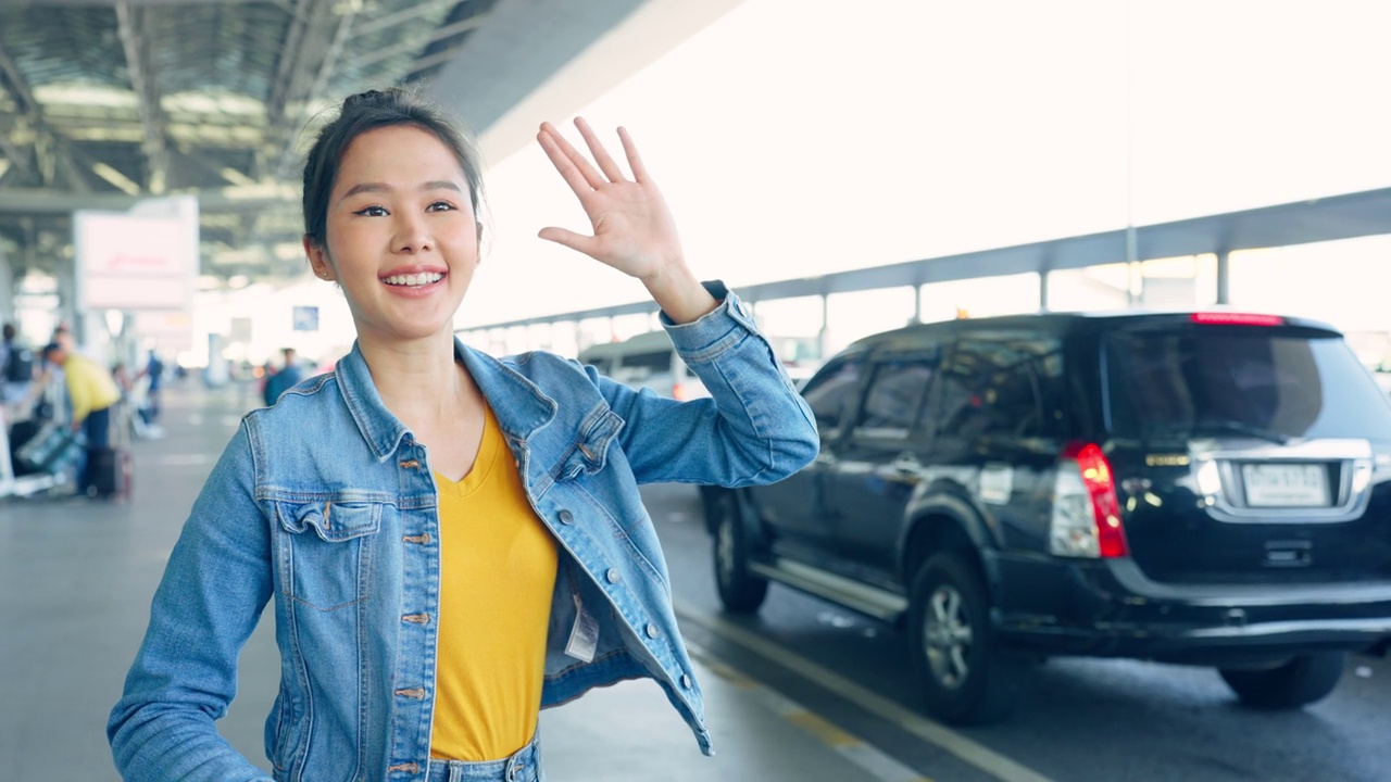 亚洲年轻女性乘客在机场前等待出租车。有吸引力的漂亮女人，游客，感觉快乐和兴奋去国外旅行从飞机假期旅行。视频素材