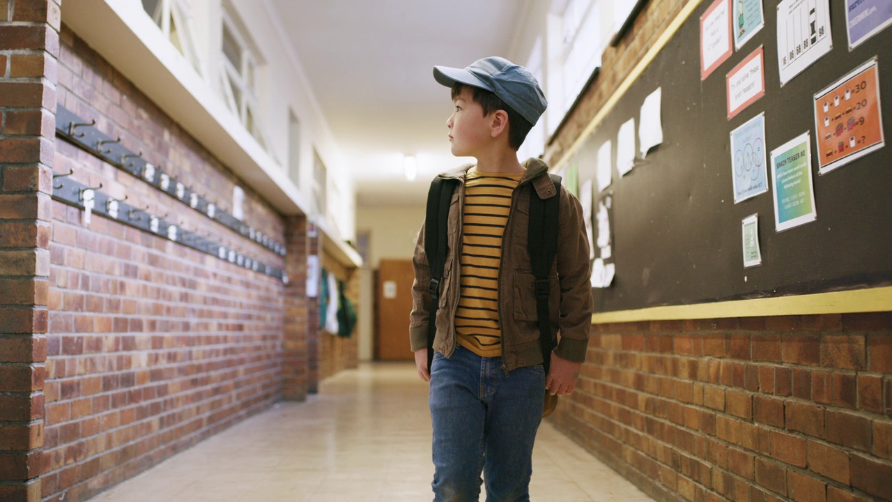 儿童学生，学校和教育背着书包去教室学习。年幼的孩子或小学男孩好奇地开始在新的教育大楼学习知识，学习和发展视频素材