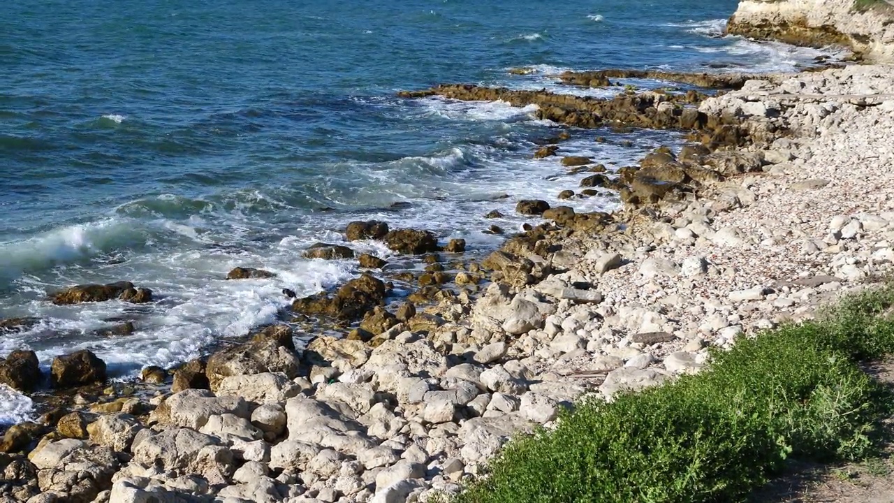 从悬崖上看到海浪，大海在岩石上破碎。视频素材