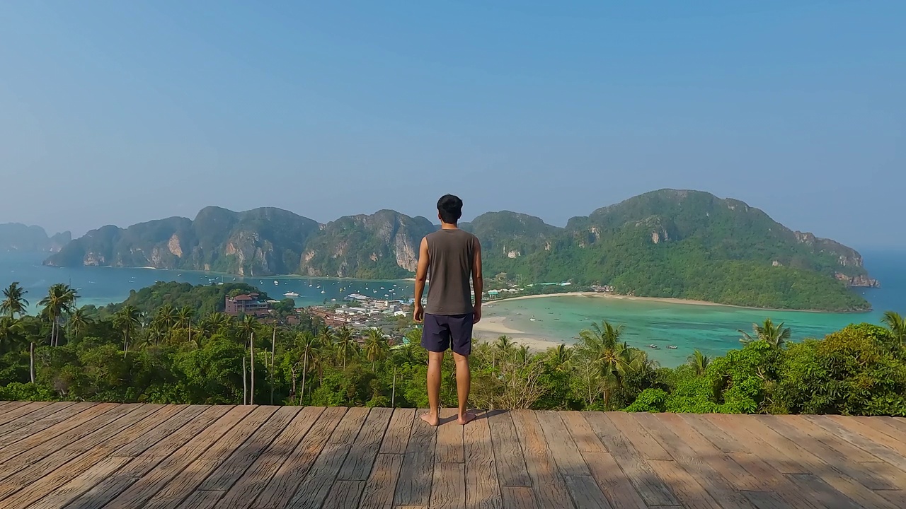 泰国甲米省的皮皮岛，一名男子在皮皮岛周围有山有海的景色视频素材