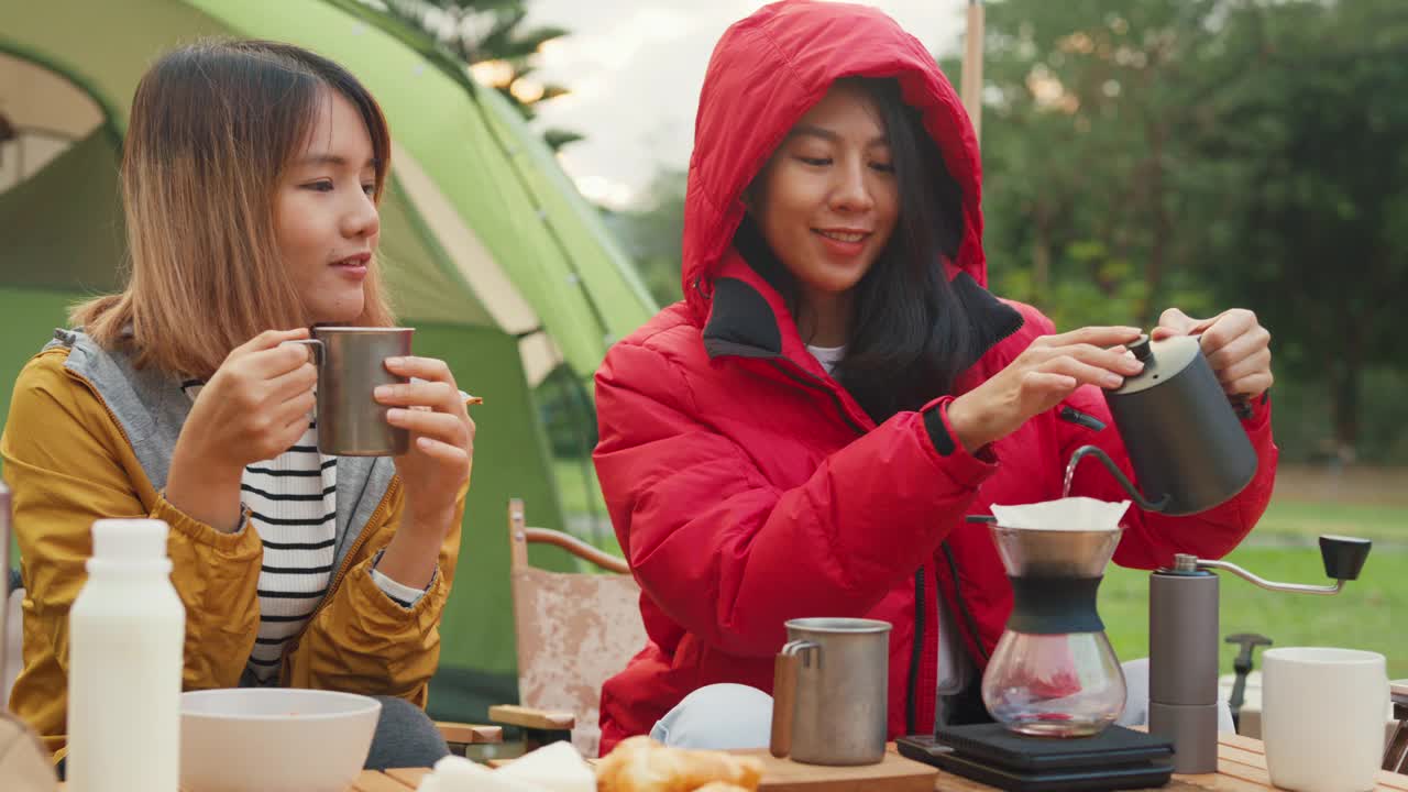 一个年轻的亚洲女子在早上与露营大篷车度假时用过滤器将水倒在咖啡地上的特写。生活方式旅行自然。视频素材