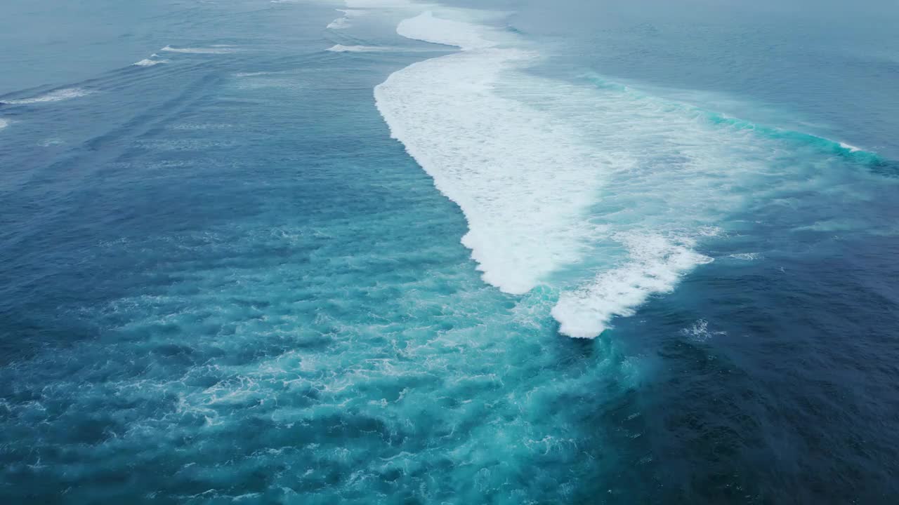 碧海碧波碧水。鸟瞰海浪与白色大卷曲。电影的流动高膨胀。上方自然水旋风日。op Shot抽象海洋景观背景视频下载