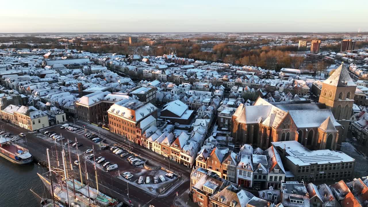 Kampen市的Buitenkerk和白雪覆盖的屋顶，一个寒冷的冬天日出视频素材