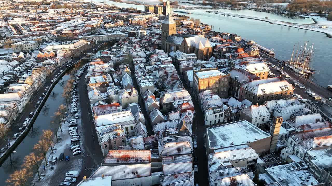 Kampen市的Buitenkerk和白雪覆盖的屋顶，一个寒冷的冬天日出视频素材