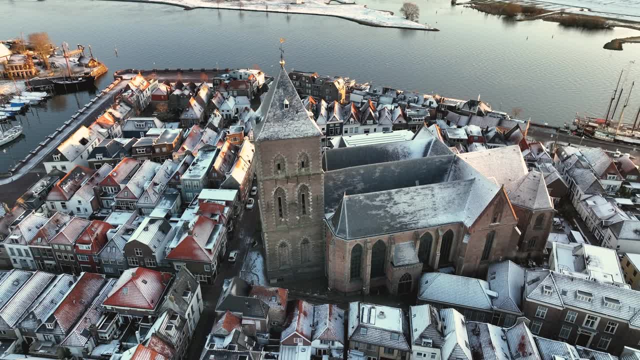 Kampen市的Buitenkerk和白雪覆盖的屋顶，一个寒冷的冬天日出视频素材