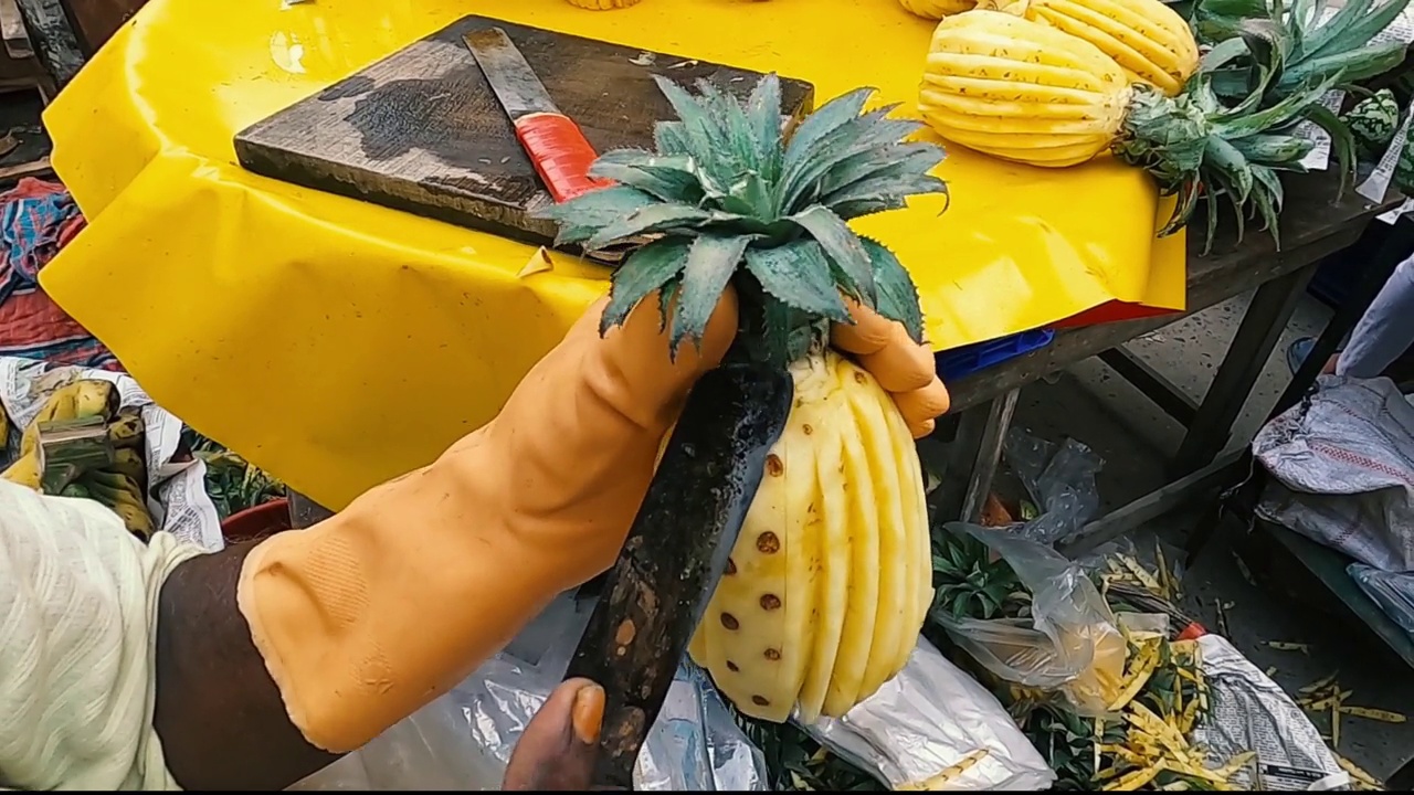 男子在街头市场切菠萝的短手。前视图平滑运动剪辑。视频下载