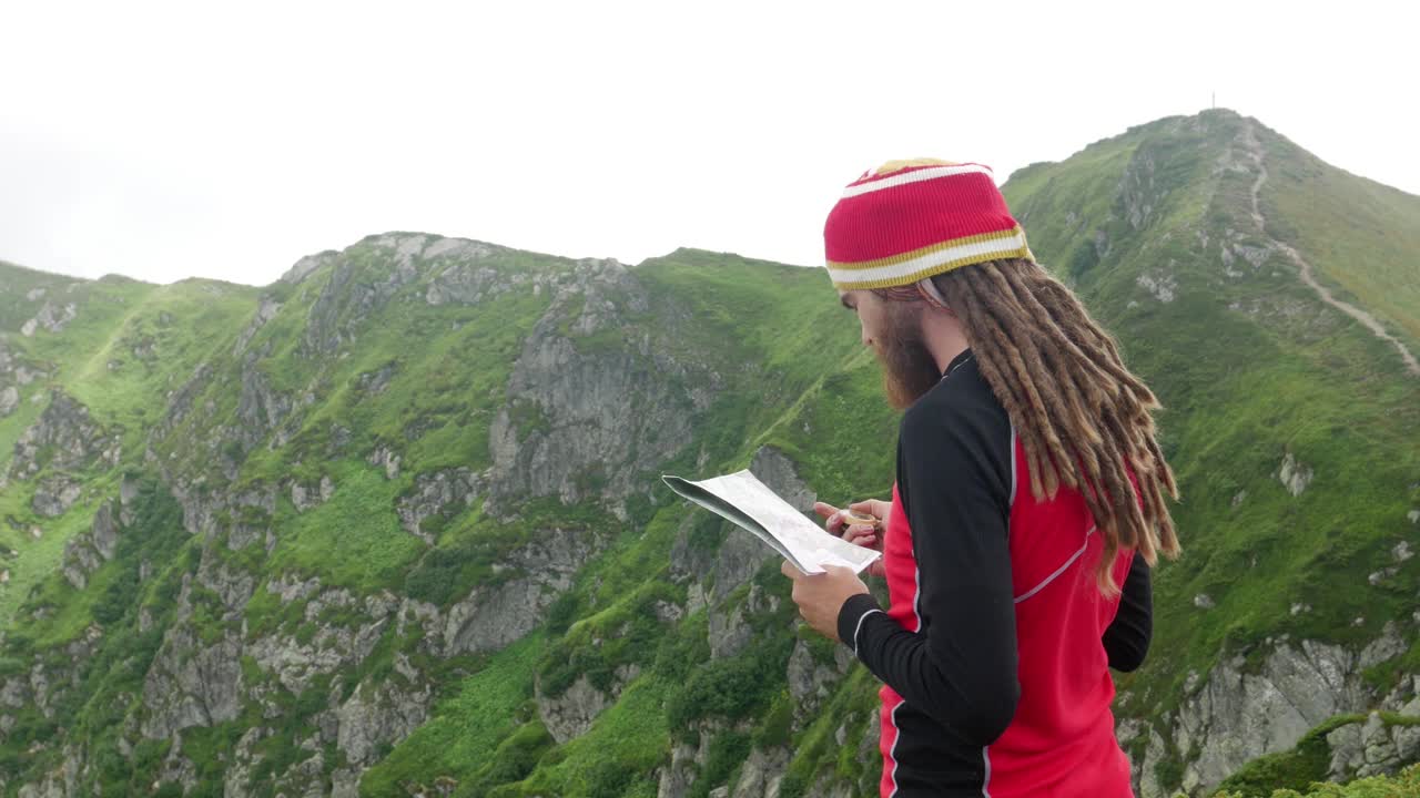 男性旅行者在山上考虑地图视频素材