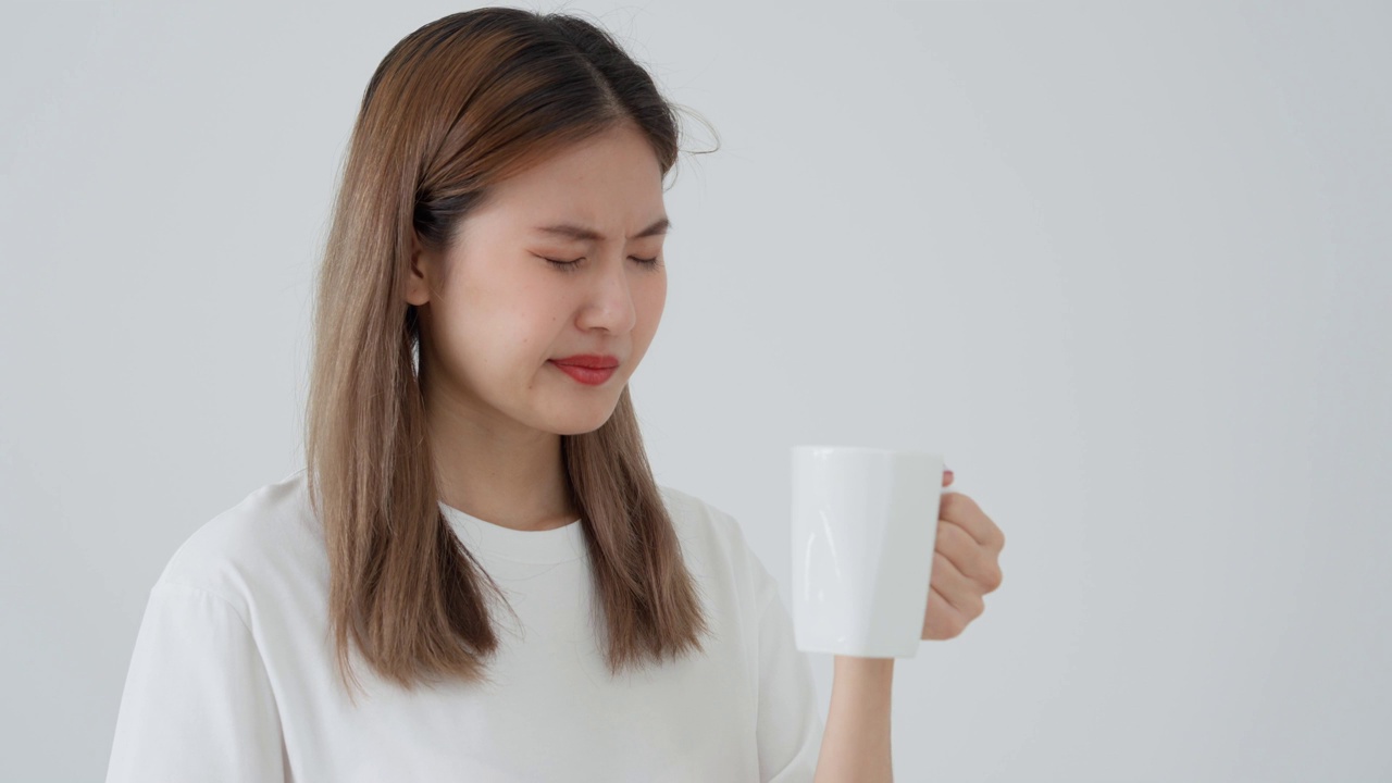 亚洲女性喝热后感觉牙齿敏感，女性患牙，蛀牙问题，牙科护理，拔牙，蛀牙问题，口臭，牙龈衰退，口腔卫生指导视频素材