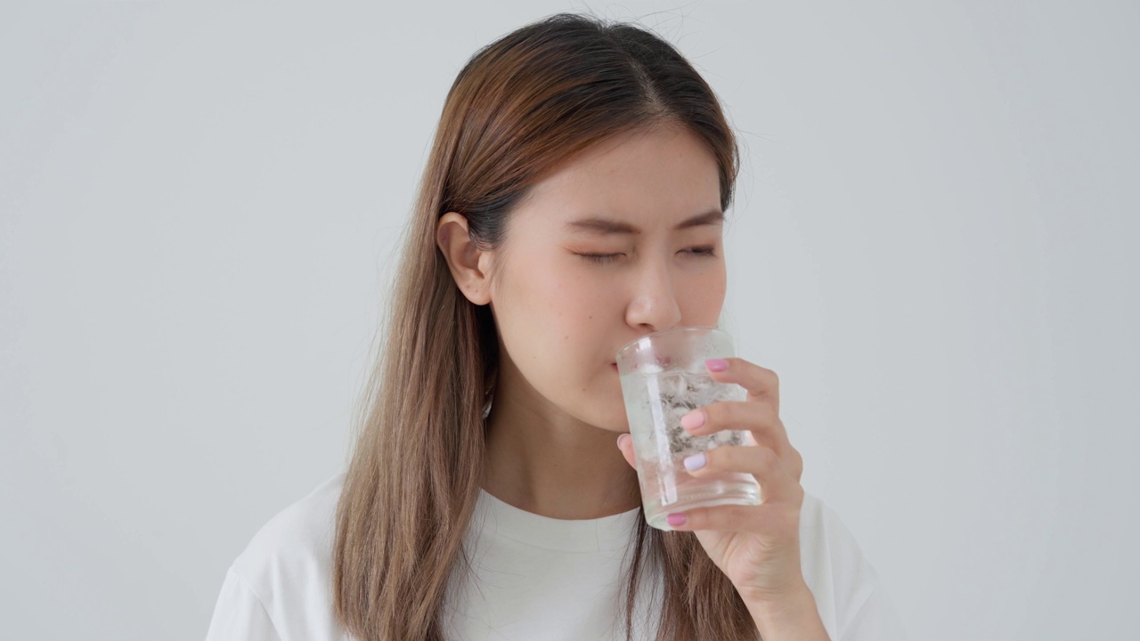 亚洲女性喝冷饮后感觉牙齿敏感，女性患牙、蛀牙问题，牙科护理，拔牙、蛀牙问题，口臭，牙龈萎缩，口腔卫生指导视频素材