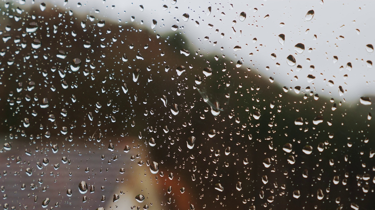 雨滴在窗玻璃上滑动。雨天，雨滴在玻璃上滴落视频素材