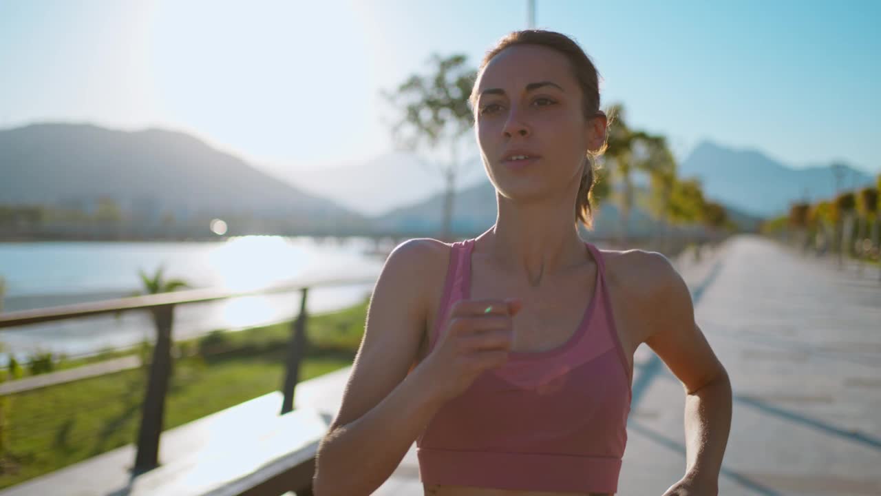 健身女子在热带公园的桥路上冲刺。健康的年轻跑步者晨跑锻炼。视频素材