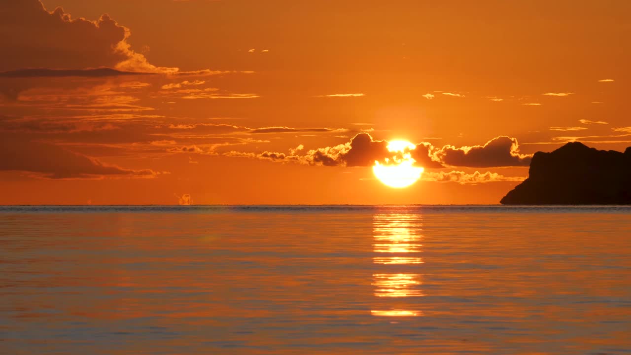 明亮的橙色大太阳在海面上落下视频素材