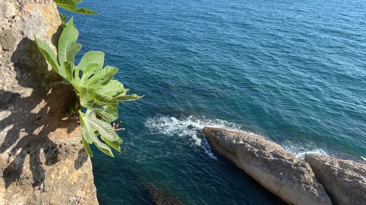 从悬崖上看蓝色的海浪。视频素材