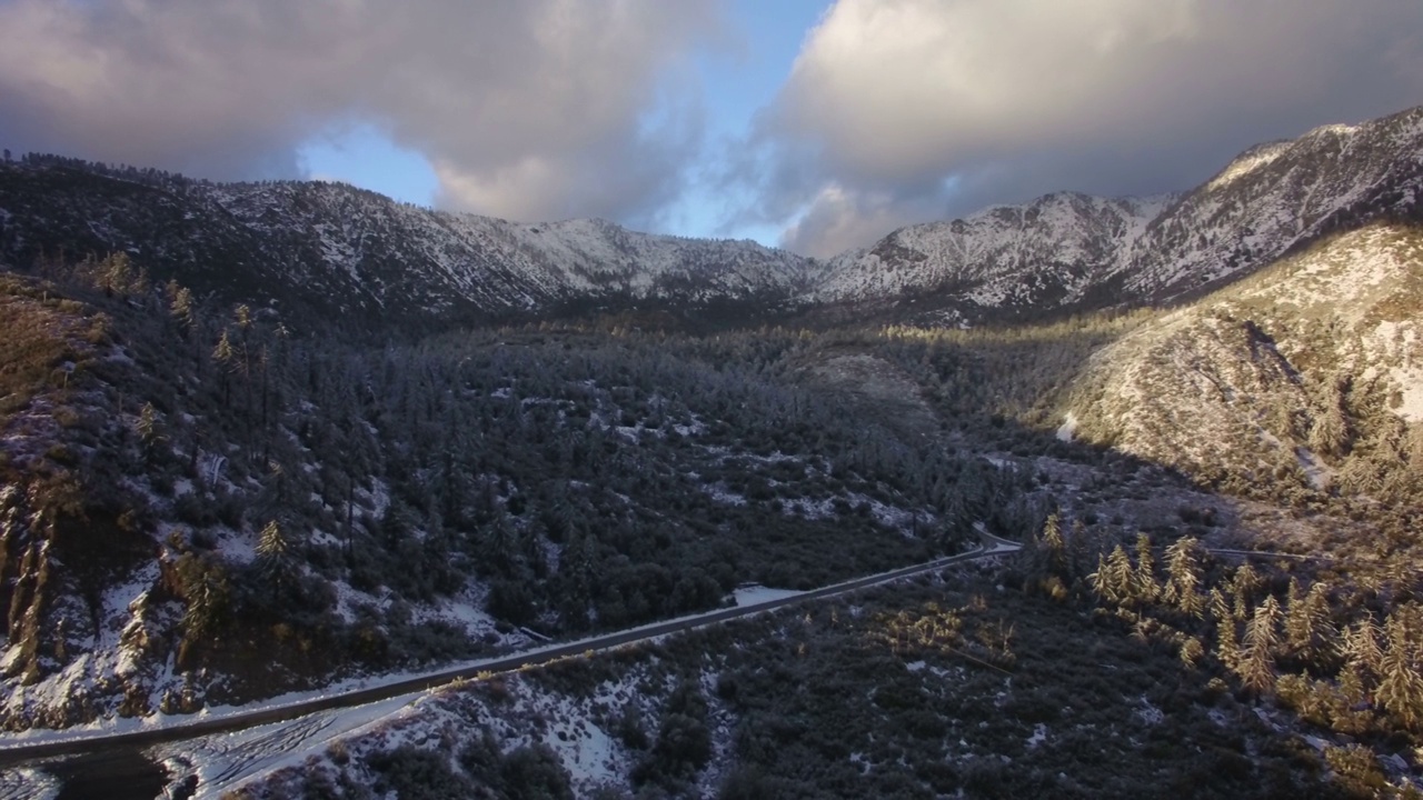 雪覆盖的高山山脊在加利福尼亚州日落航拍旋转左视频素材