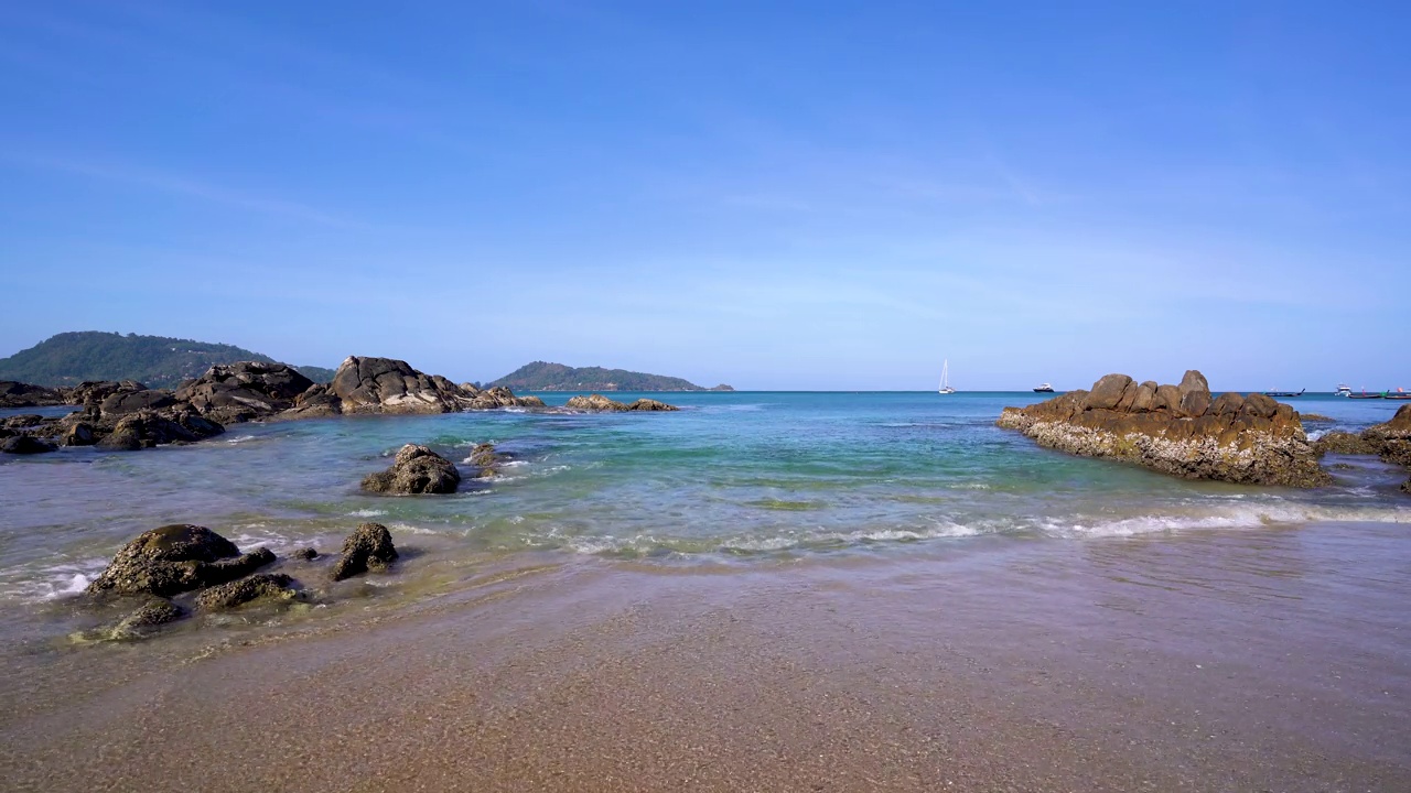 4k晶莹剔透的海滩，海浪，岩石，船只和山脉在巴东海滩，普吉岛，泰国。视频素材