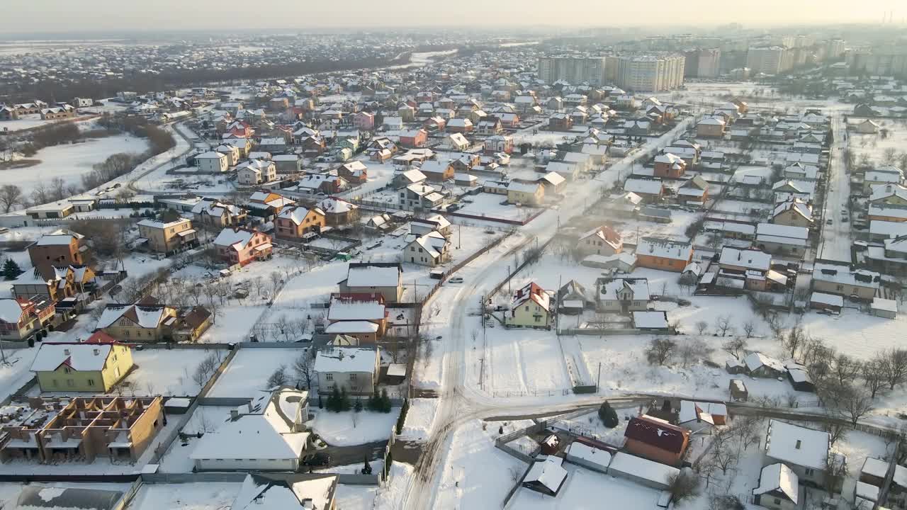 在寒冷的冬天，郊区郊区的私人住宅屋顶被雪覆盖的鸟瞰图视频素材