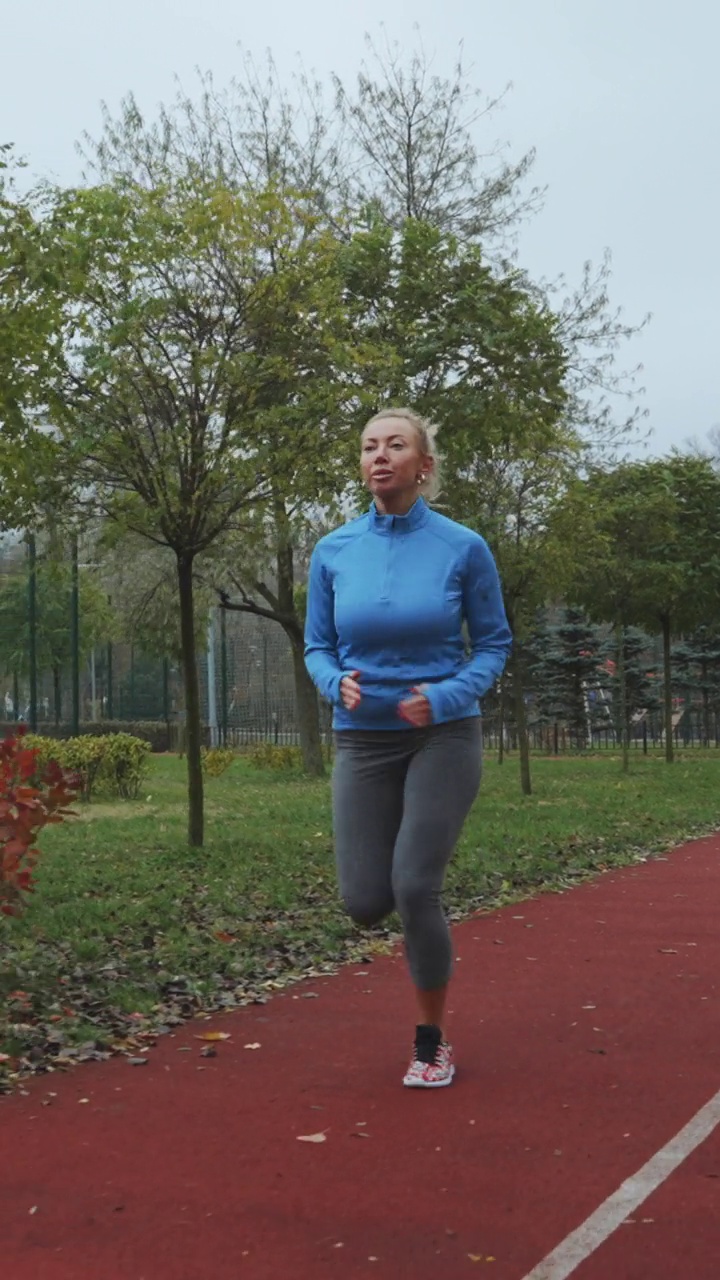 竖屏:成年女子在秋天的早晨在户外慢跑视频素材