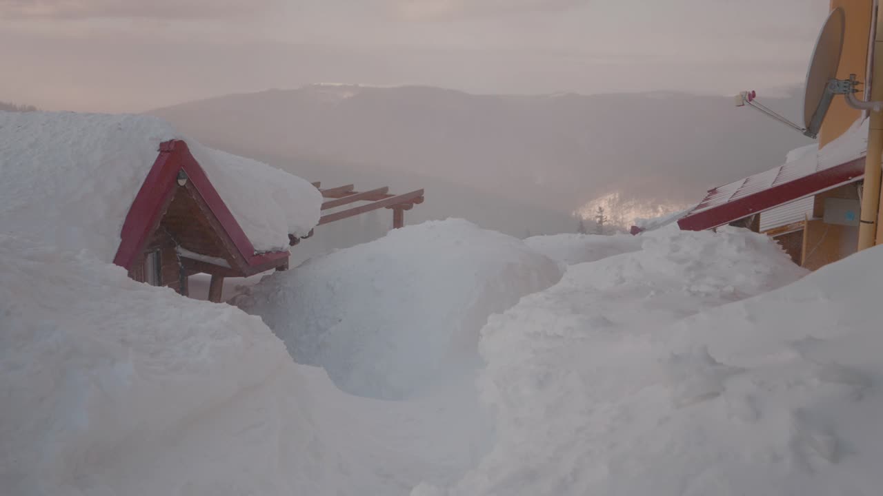 成堆的雪几乎覆盖了整个小屋。视频素材