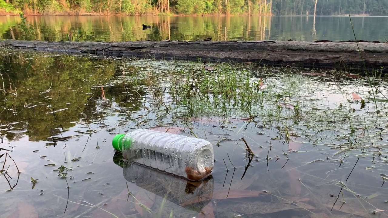 用过的塑料瓶漂浮在湖面上。视频素材