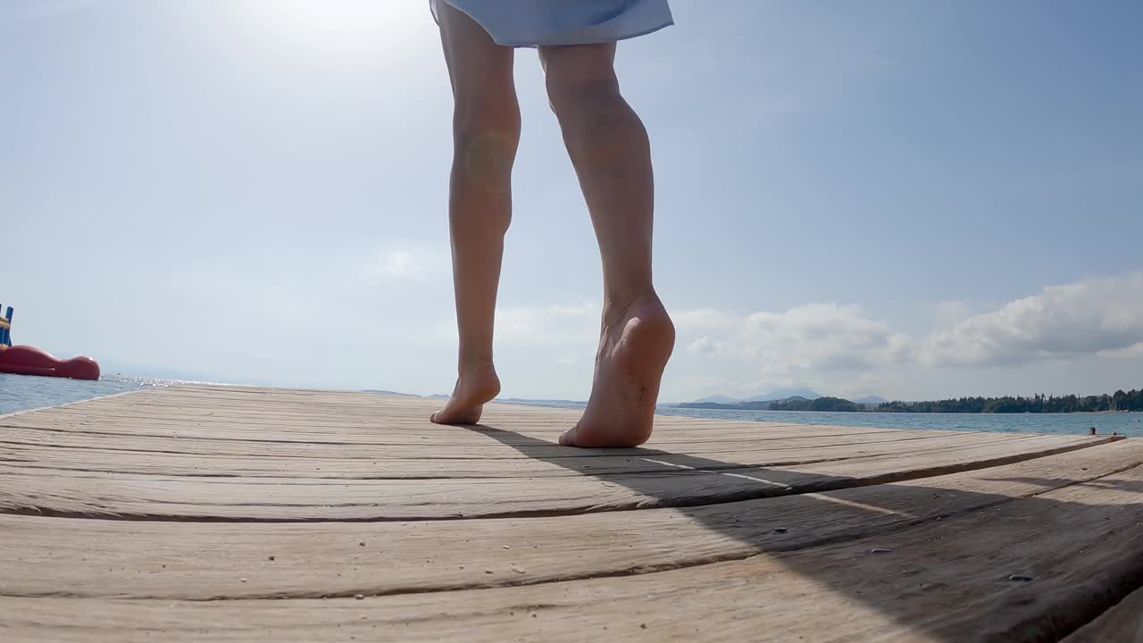 有魅力的女人走过热带岛屿的木码头，慢动作视频素材