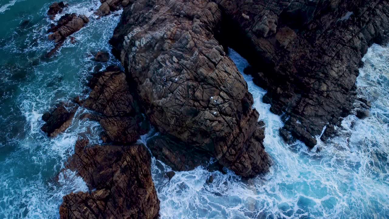 海浪与泡沫飞溅在岩石海岸视频素材