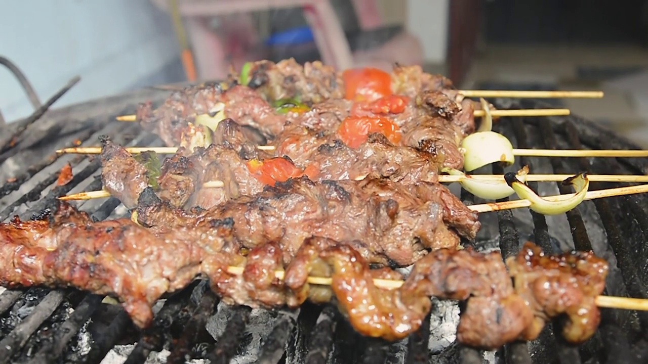 在烤架上准备烤肉的手。在烤架上烤牛肉的人，概念自制烤牛肉。视频素材