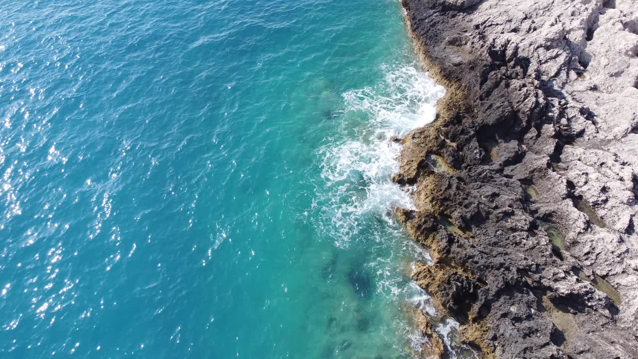 在波尔图卡茨基海滩上，海洋撞击岩石的鸟瞰图。莱夫卡达岛夏季的热带绿松石海。视频素材