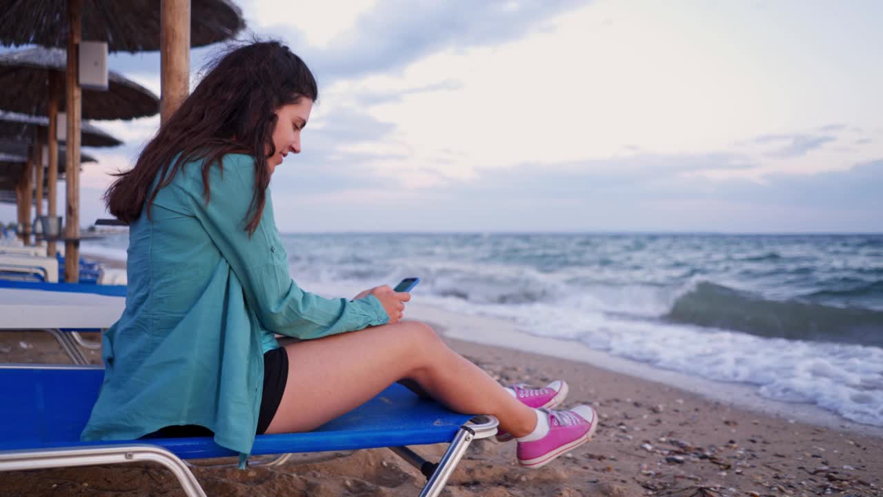 海边用智能手机的女人视频素材