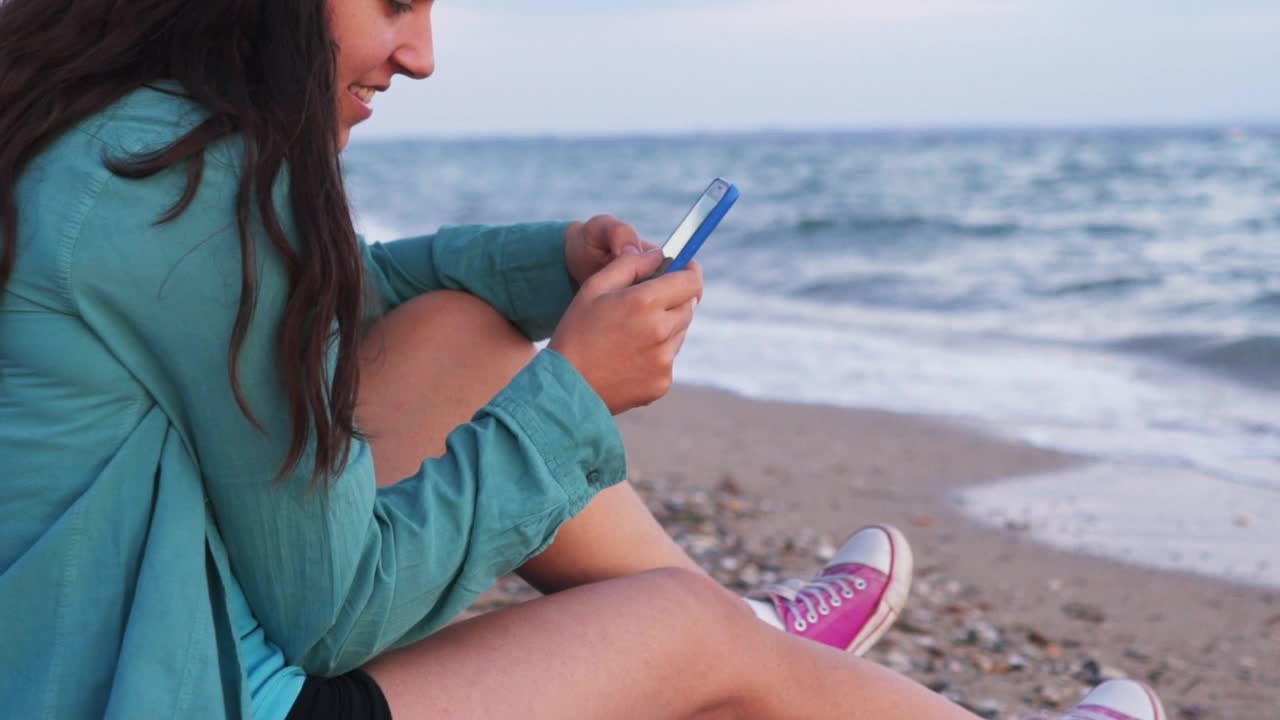 海边用智能手机的女人视频素材