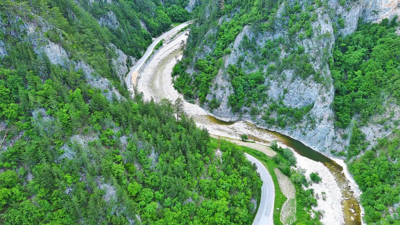 在罗多普山脉(Rhodope Mountains)，一条蜿蜒的道路穿过布满植物和树叶的山谷视频素材