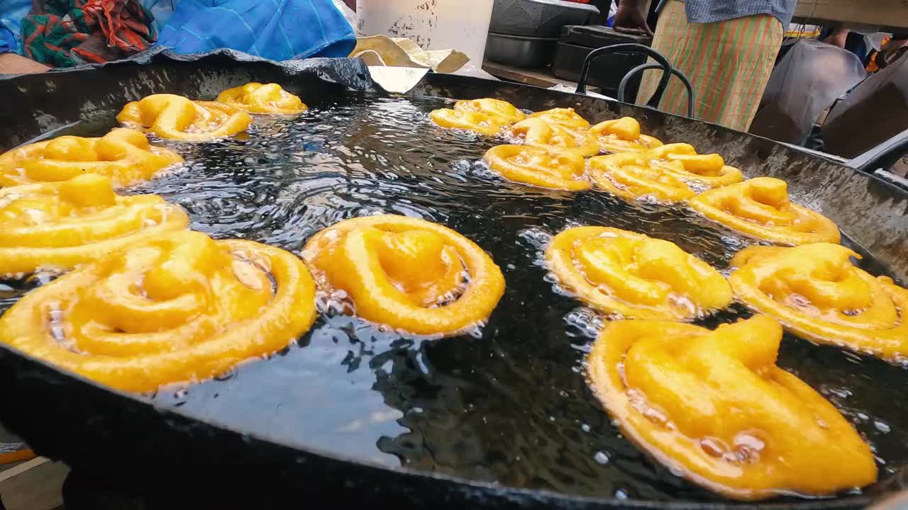 新鲜印度甜点Jalebi。甜Jalebi。生吉拉皮油炸4k视频剪辑。在热的大锅上做吉拉皮。视频下载