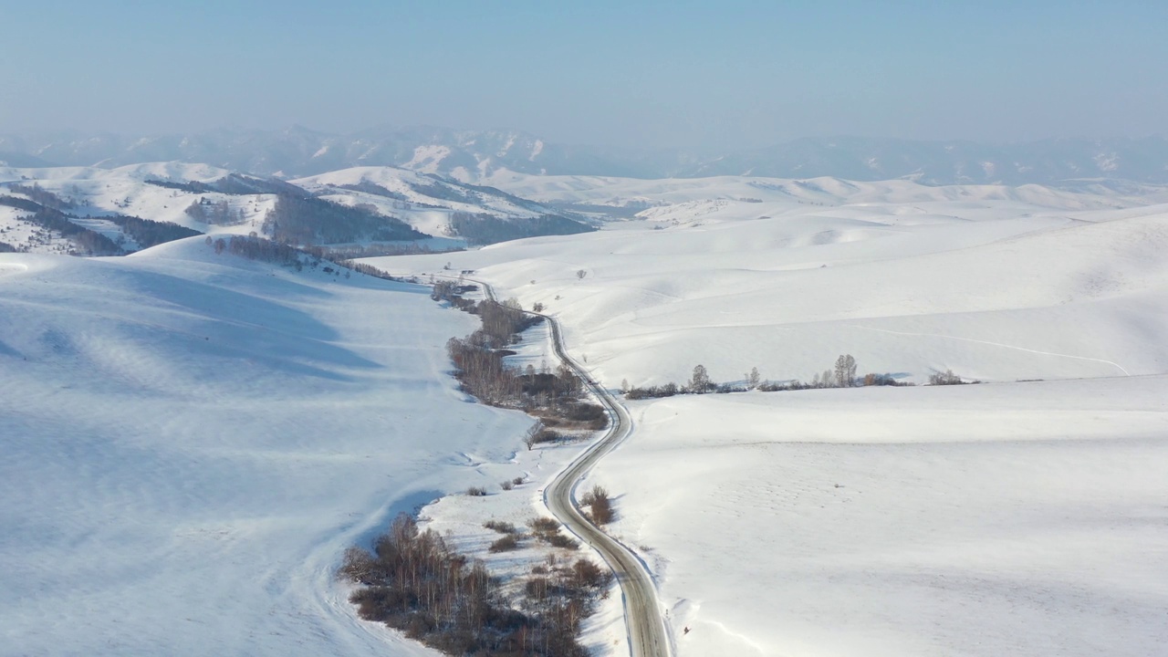 阿尔泰冬季道路和积雪下树木的航拍视频。西伯利亚,俄罗斯视频下载