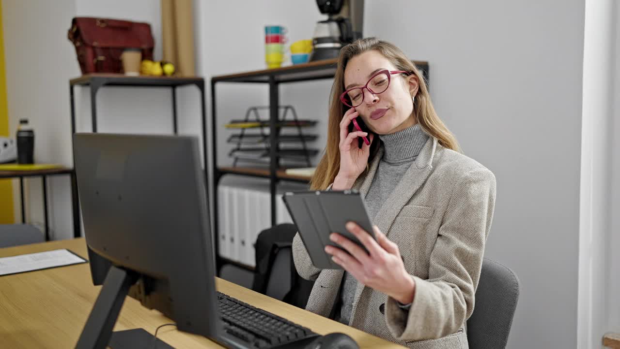 年轻的白人女性业务工作者使用触摸板在办公室用智能手机通话视频素材