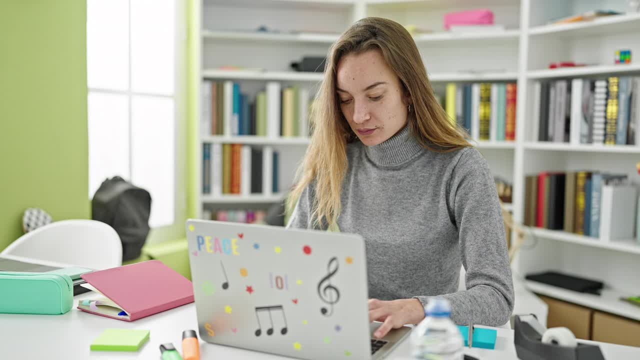 年轻的白人女学生强调使用笔记本电脑在图书馆大学学习视频素材