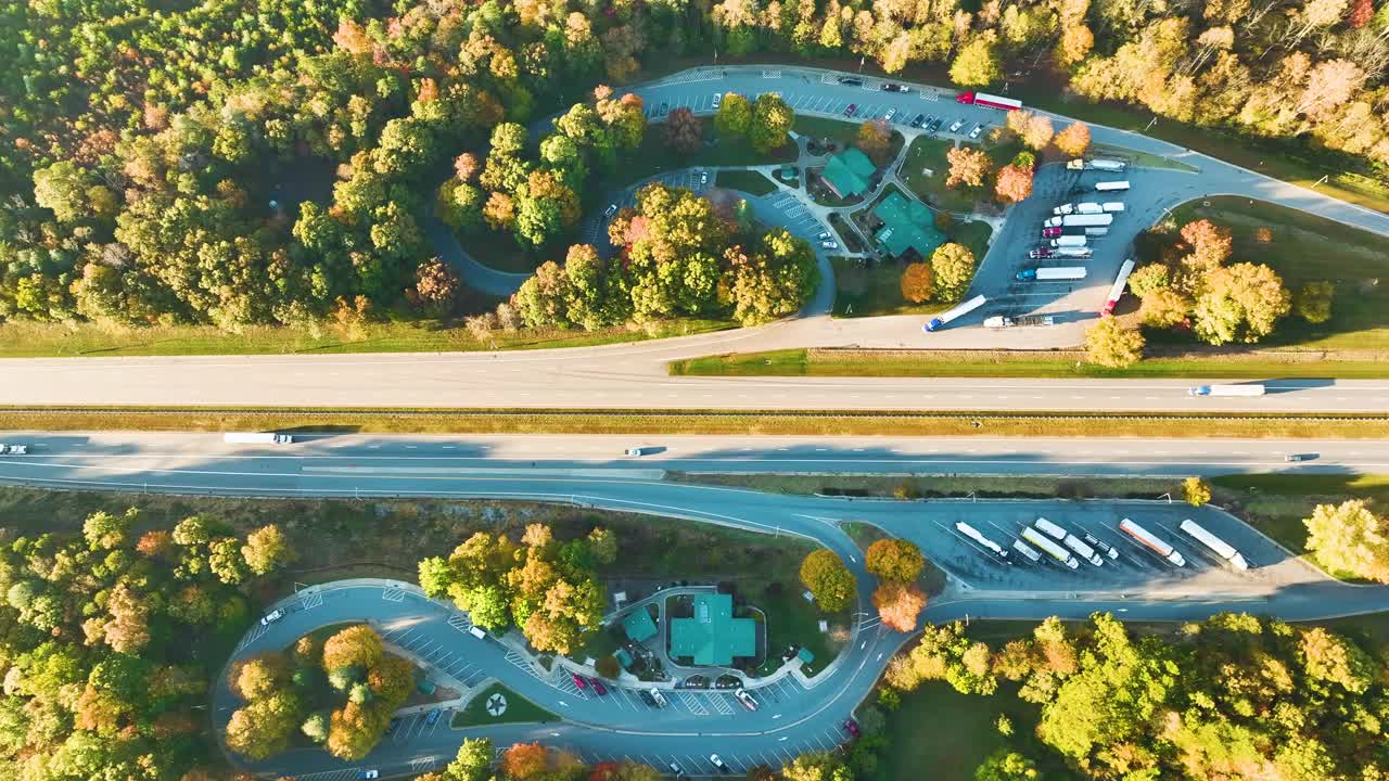 大型卡车停靠点，靠近繁忙的美国州际高速公路，有快速行驶的汽车和卡车。州际旅行期间的休闲停车场视频素材