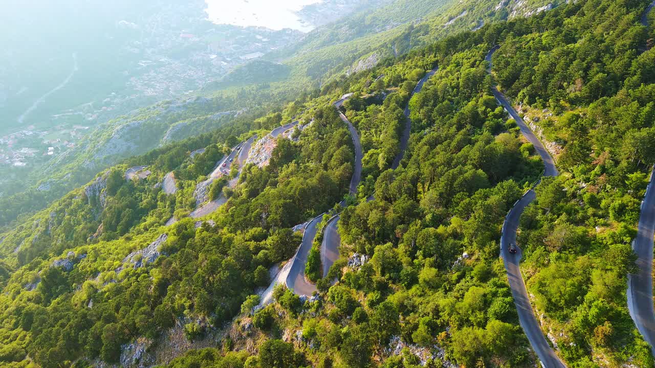 蜿蜒的道路-洛夫琴斯基蜿蜒的危险转弯，通往蒙的内哥罗山脉的顶部覆盖着植被视频素材