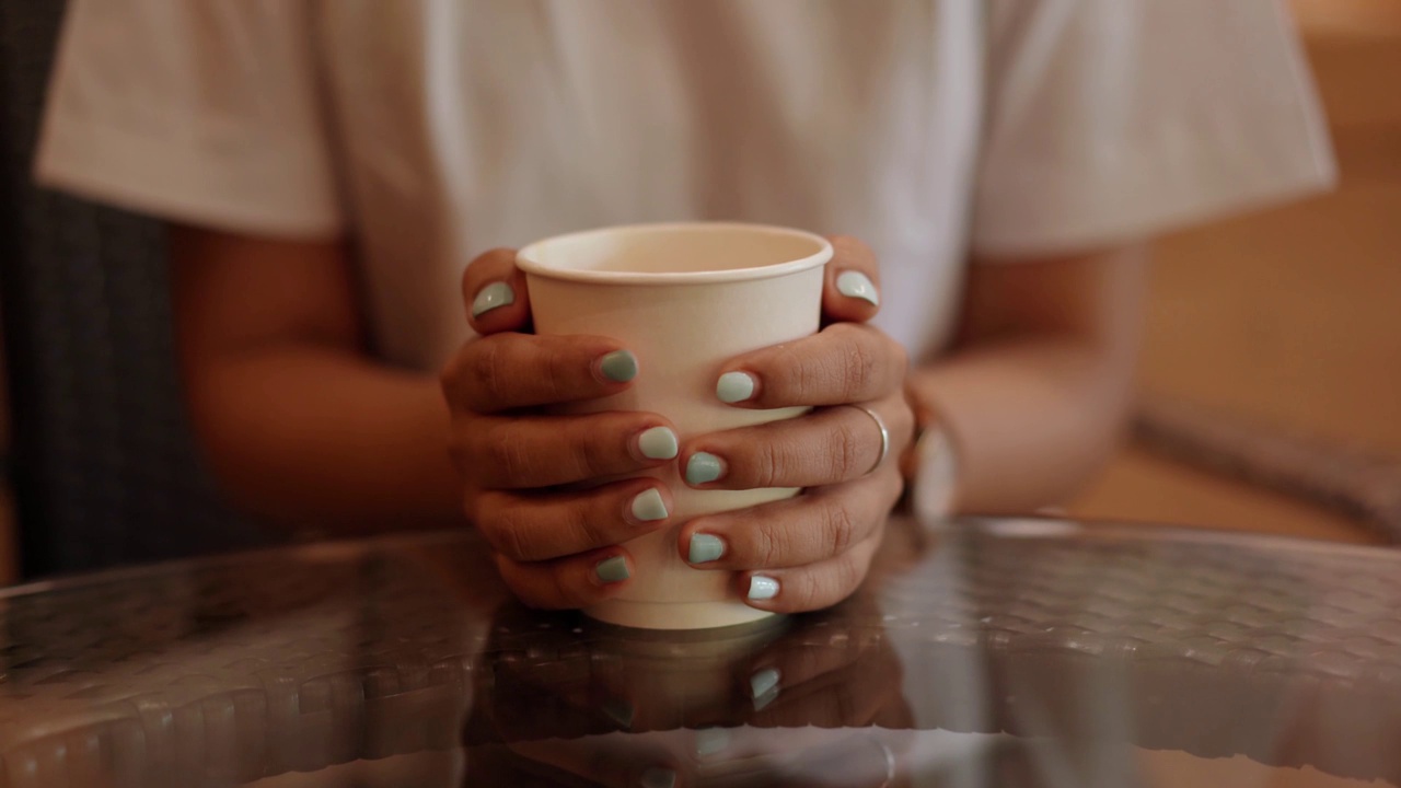 女人手里拿着纸杯咖啡。视频素材