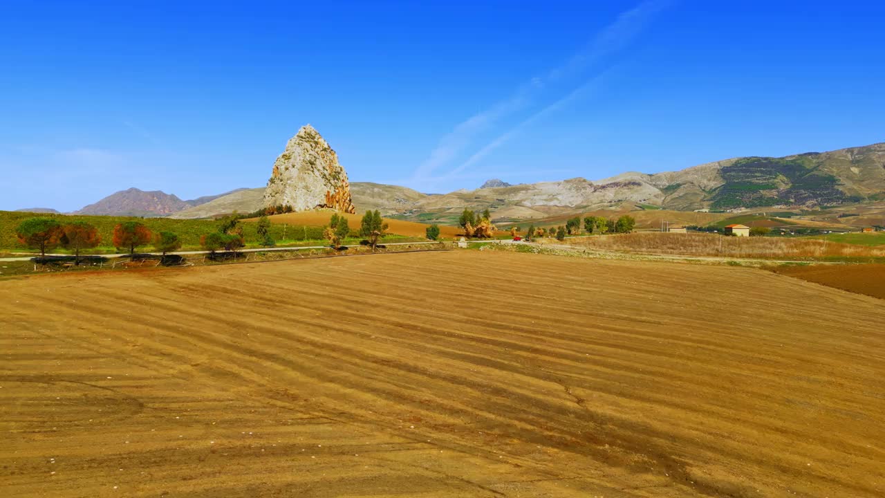 岩石形成的无人机镜头-在农业领域中山上的Pizzo Pietralunga。大岩石在景观附近Borgo Schiro -鸟瞰图-西西里岛，巴勒莫省，Monreale，意大利视频素材