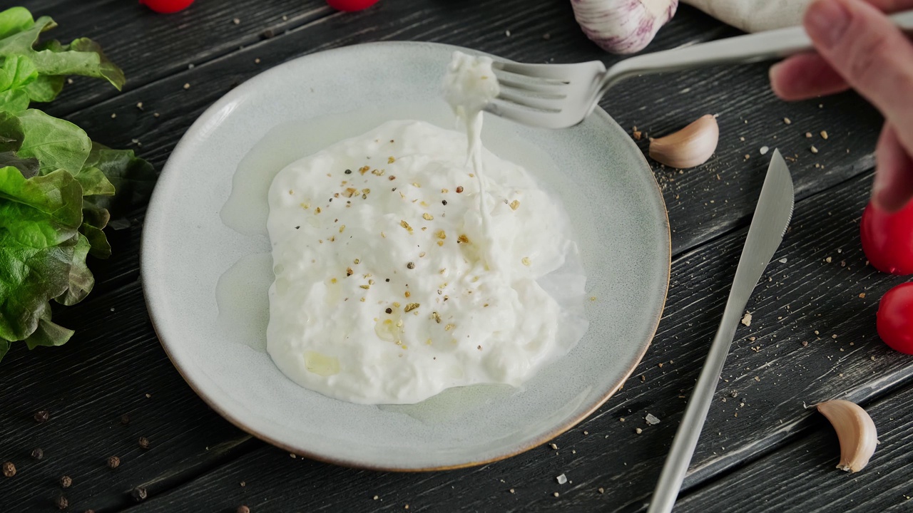 鸡蛋干酪汤奶酪。意大利拉伸凝乳奶酪浸泡在牛奶中，Stracciatella di bufala，凝乳新鲜奶酪制成的碎片，视频剪辑，高品质的4k镜头视频素材