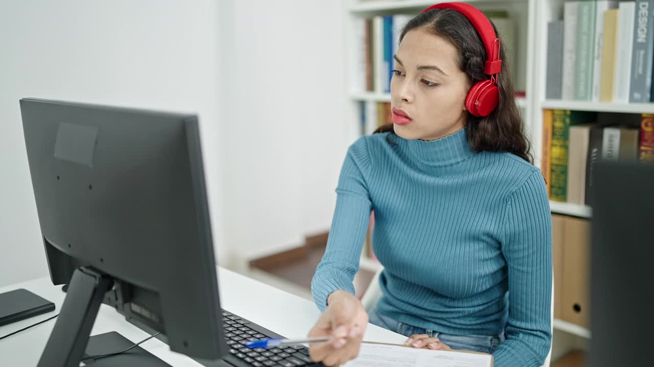 年轻美丽的西班牙女学生使用电脑在大学教室的在线课堂上做笔记视频素材