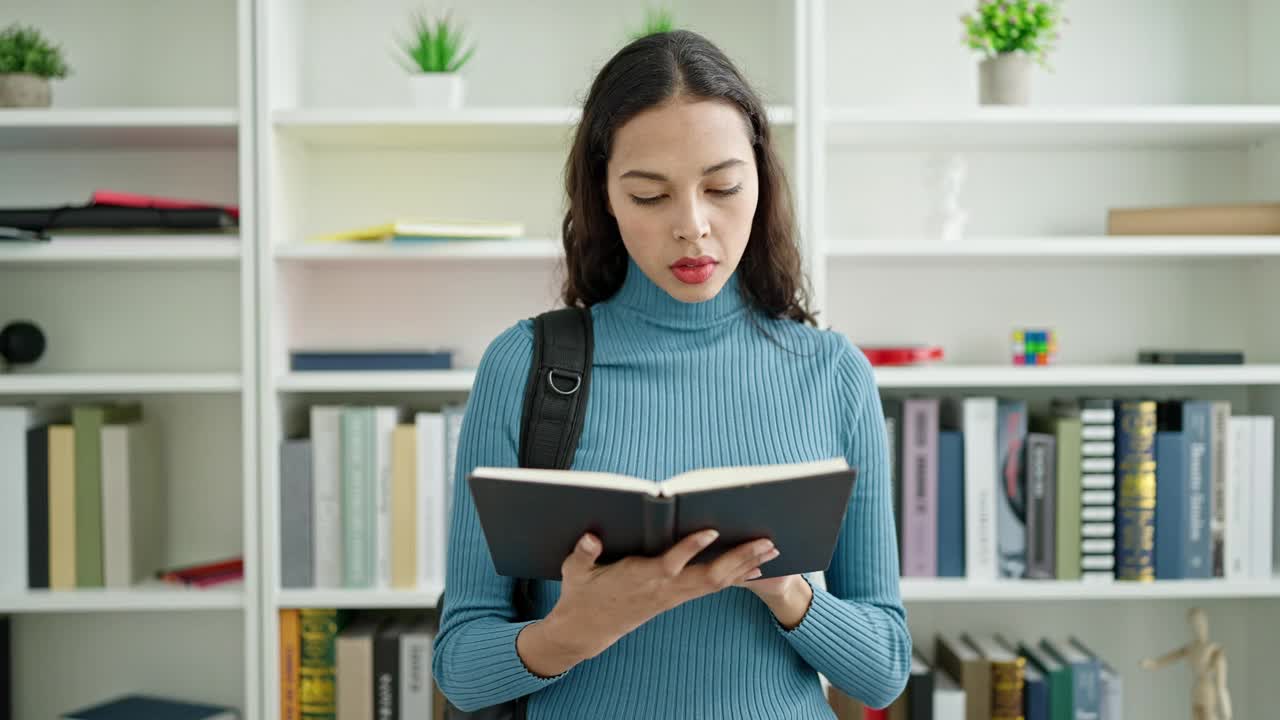 年轻美丽的西班牙女学生读书做沉默的手势在大学教室视频素材