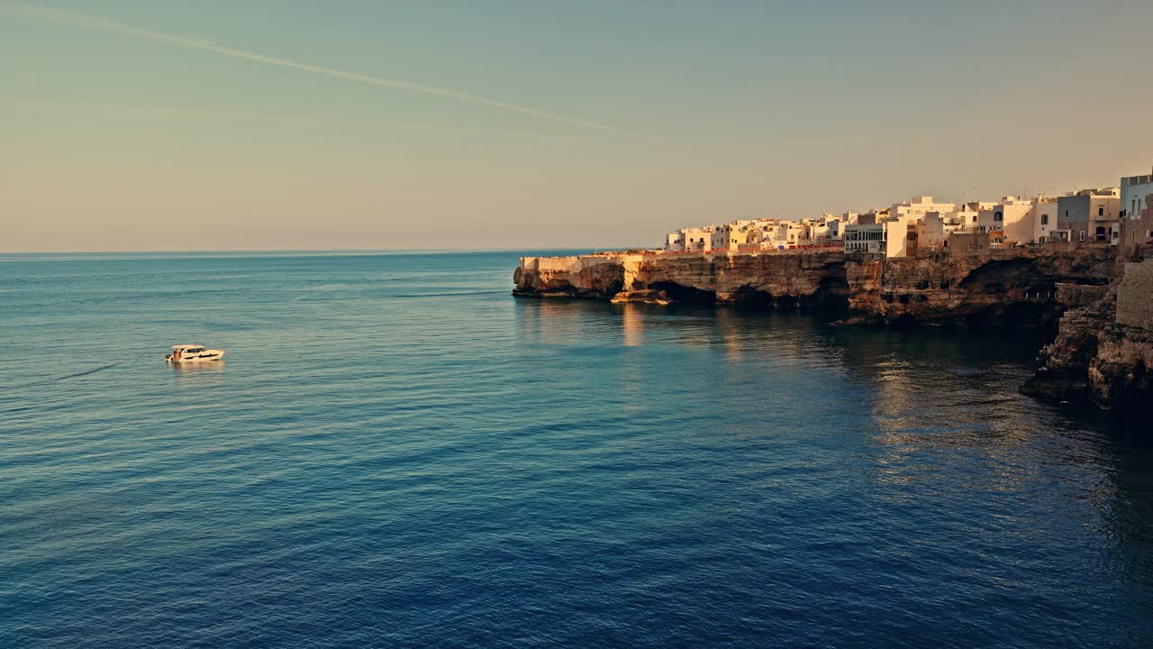 在Polignano a Mare，田园诗般的大海和天空映衬下的悬崖上的建筑视频素材