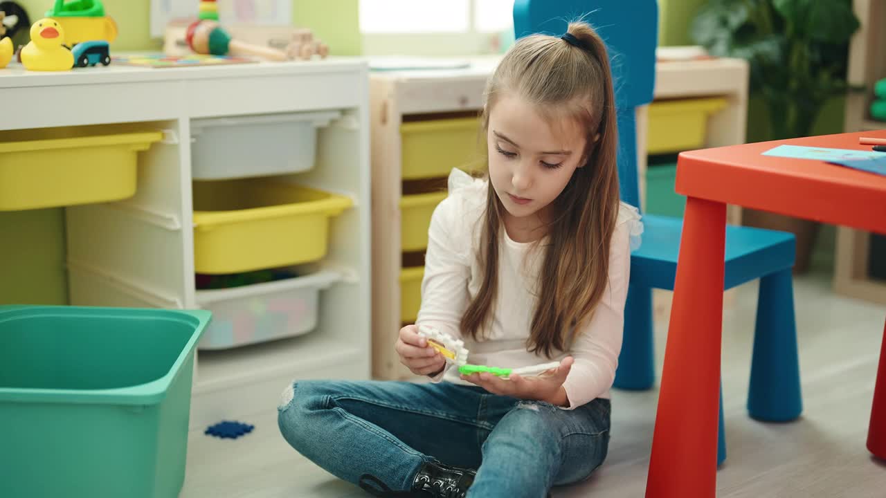 可爱的西班牙女孩坐在幼儿园地板上玩积木视频素材